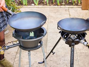 Two outdoor wok burners on a patio.