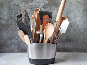 A stainless steel utensil crock filled with various utensils.