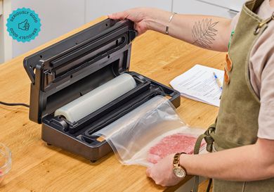  A person using an Anova vacuum sealer