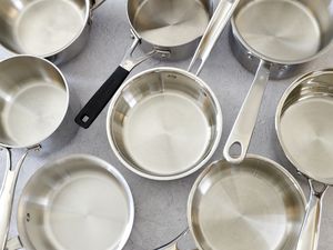 a number of small saucepans on a grey surface