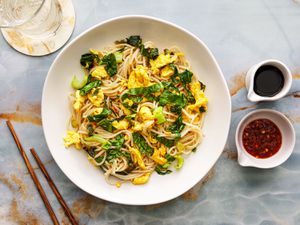 Overhead view of stir fried noodles next to sauces