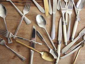 An assortment of silverware on a wooden surface