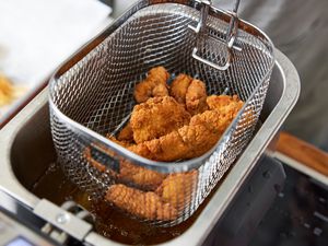 Fried chicken tenders in a deep-fryer basket