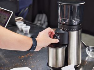 Oxo conical burr grinder being used 