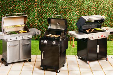 Three gas grills side by side on a patio