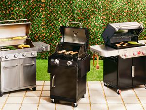 Three gas grills side by side on a patio