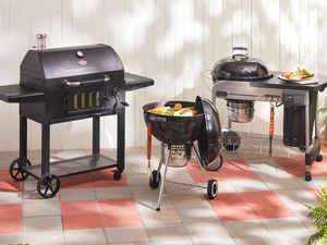 Three of our recommended charcoal grills on a patio