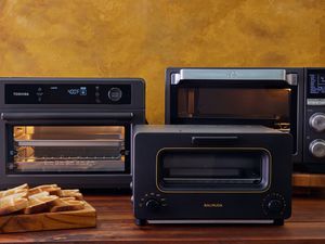 Three air fryer toaster ovens on a wooden countertop