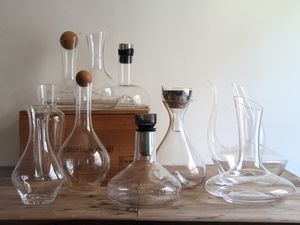 a group of glass wine decanters on a wooden surface